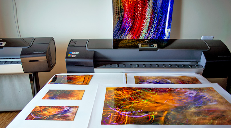 In Lindquist Studios' print studio, dye-sub proof prints (left) and proof prints from Mark's HP Z3200ps printer (right). Full-size print (background) is to check for color, noise, and sharpness of another image.