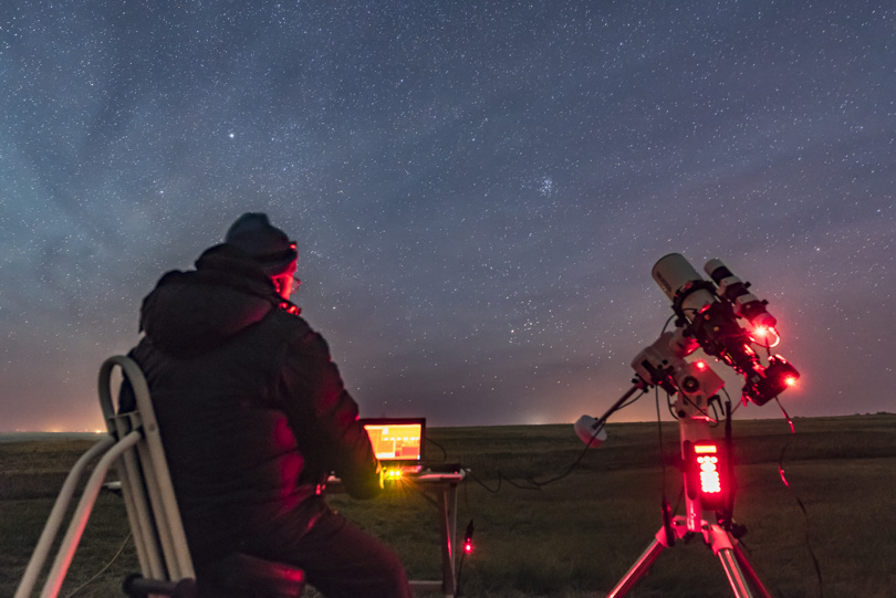 Me, monitoring the autoguiding as my DSLR camera takes a series of deep-sky images of a nebula in Cassiopeia, using the TMB 92mm refractor and the Sky-Watcher AZ-EQ5 mount, being tested here. Shot from home Nov 4, 2015. Streaks of airglow fill the sky.