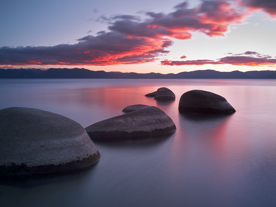 This image was taken on a 10-day solo trip to Lake Tahoe. I hiked to this particular location several times over the days I was there, and scouted out several vantage points to photograph for a return trip at sunset and sunrise. Although this shot was not the one I planned for, everything seemed to come together, and I had just seconds to respond. I used a long exposure to soften the water, and I tried to place the rocks in a favorable position that mimicked the clouds somewhat. Often I find my best images are ones I have not anticipated or planned for. It teaches me humility and to always remain open to whatever nature presents. Being in the area for several days greatly increases your chances of getting a unique shot like this.