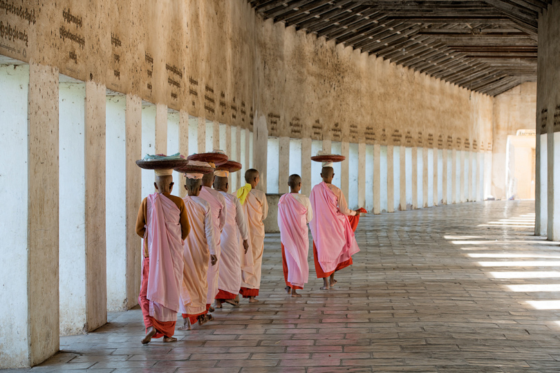 Nuns carrying baskets of food through covered causeway to Shwezigon temple Sony A7RII w/Sony f2.8 70-200mm
