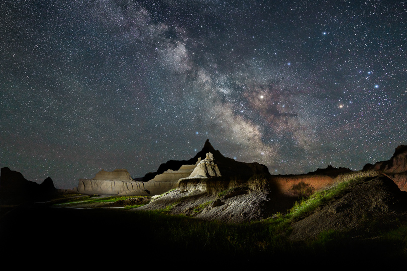 The Milky Way over the Badlands. Again this was done in two exposures, a set of tracked frames for the sky stacked in Photoshop to reduce noise and a light-painted foreground. The red-orange color on the right is from the headlights of a passing car.