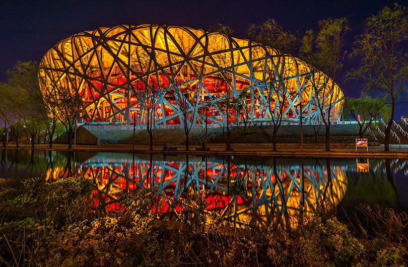 The National Stadium in Beijing, also known as “The Birds Nest”, reflected on water.