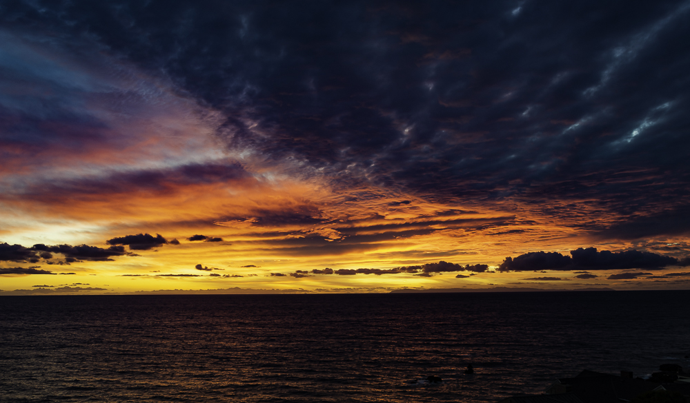 Opposing blue & red colored clouds as the sun sets over Catalina