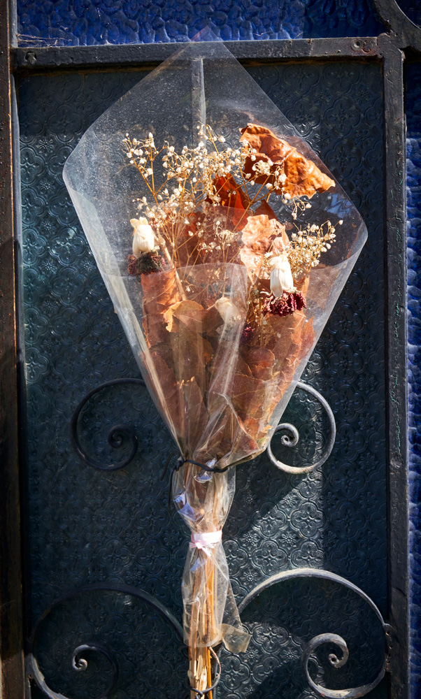 Flowers in the wrapper placed on a mausoleum door