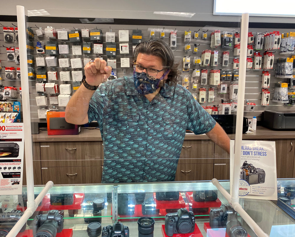 Phil Showing off one of the many plastic shields that are stationed around the store.