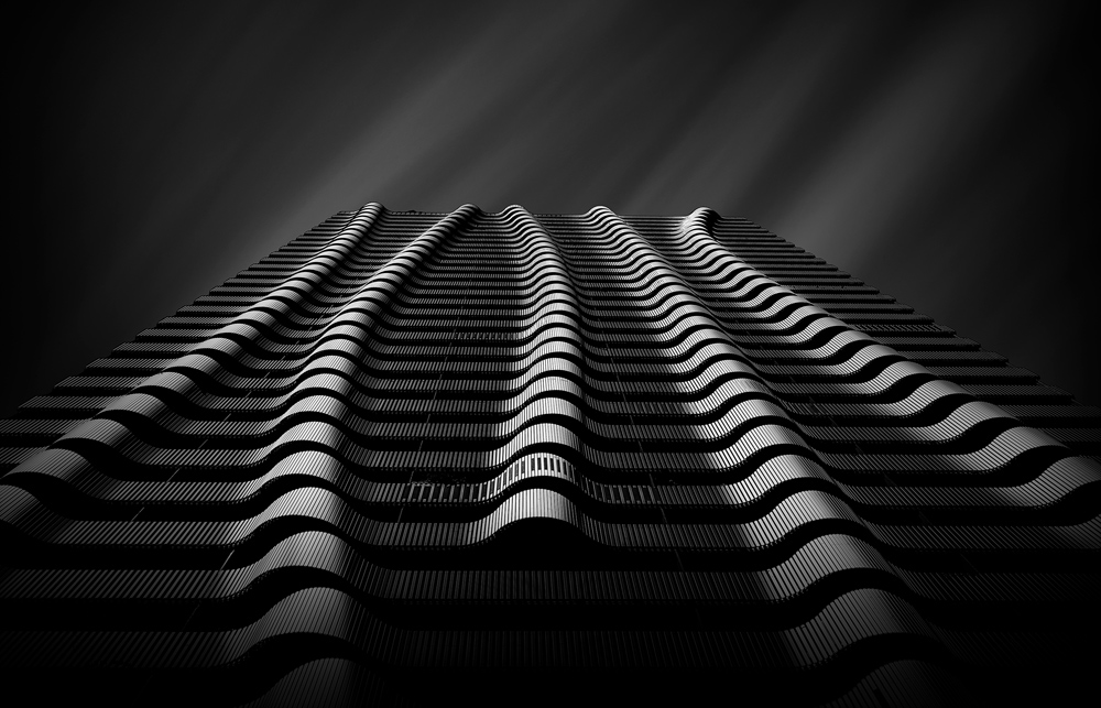 Hans Wichmann (Germany) "City Waves" Skyscraper in Vienna / Austria. Photographed upwards with light from the side. Edited with hard contrasts in Photoshop. The sky was photographed separately and then inserted. https://hans-wichmann.myportfolio.com/