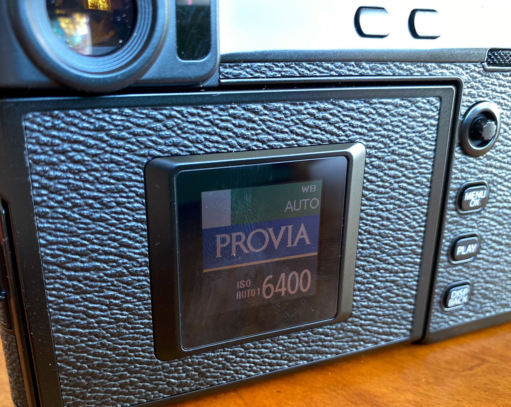When the rear screen is closed there is a small LCD screen that can show the film simulation being used or the status of the camera. 