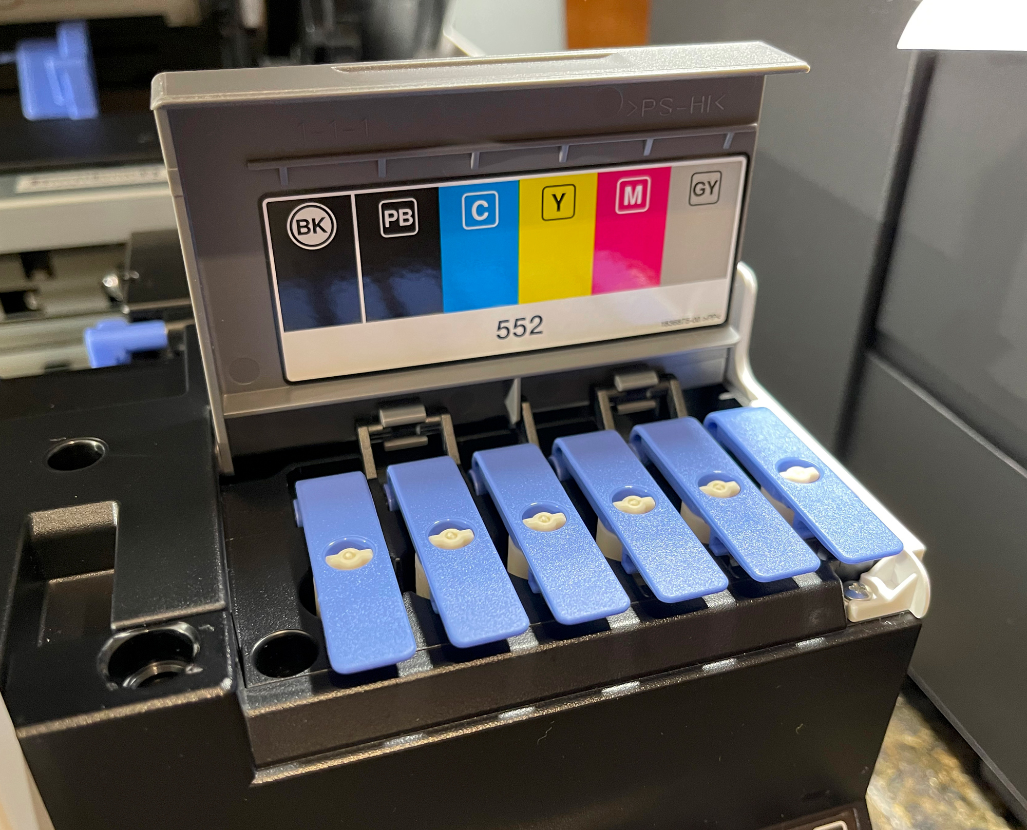 The ink tank cover exposes where the bottles of ink will oad the tanks