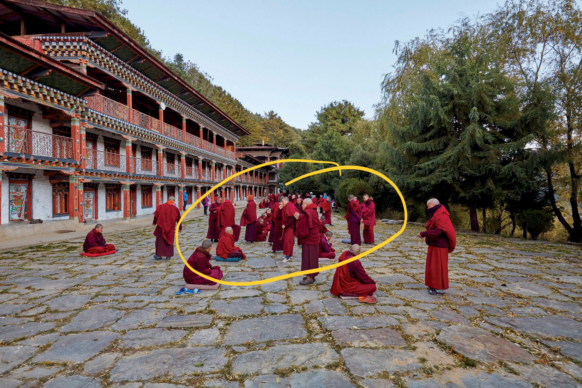 There is no single approach to framing - it all depends on what you want to show or communicate. Here a group of monks in Bhutan are debating, so the framing might be appropriate. However, if the idea behind the photo were to show a monk making a point in his debate, then the framing is not successful. The monk is too small within the frame. We need a much tighter framing