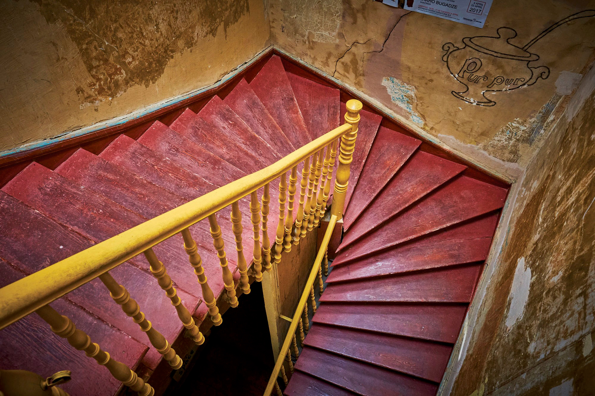 The standard eye-level view of the staircase includes lots of surrounding distractions, whereas the view looking back down from the top of the staircase is contained with fewer distractions and much stronger compositionally.