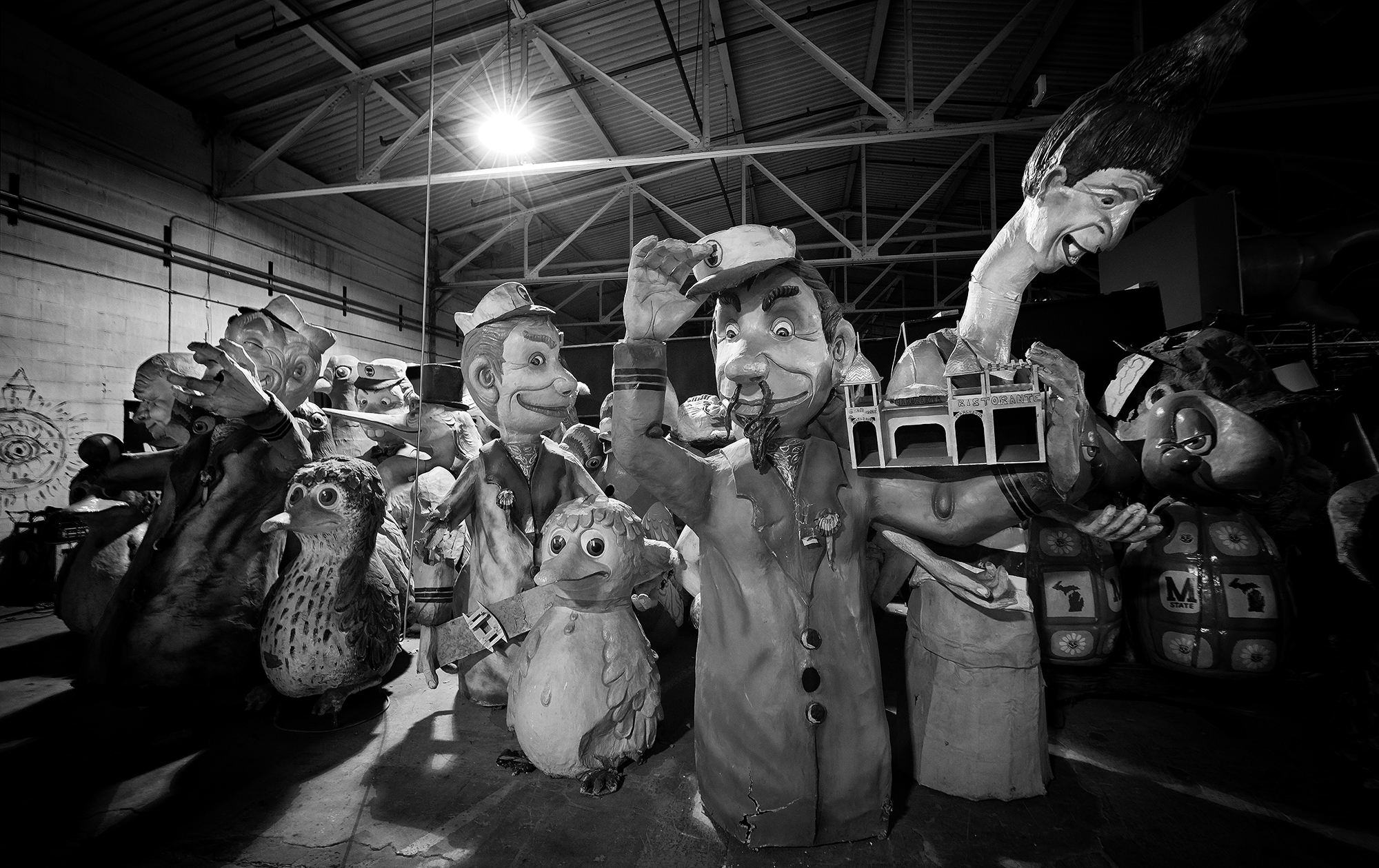 Black and white photo of several cartoonish statues of sailors, animals, and other people.