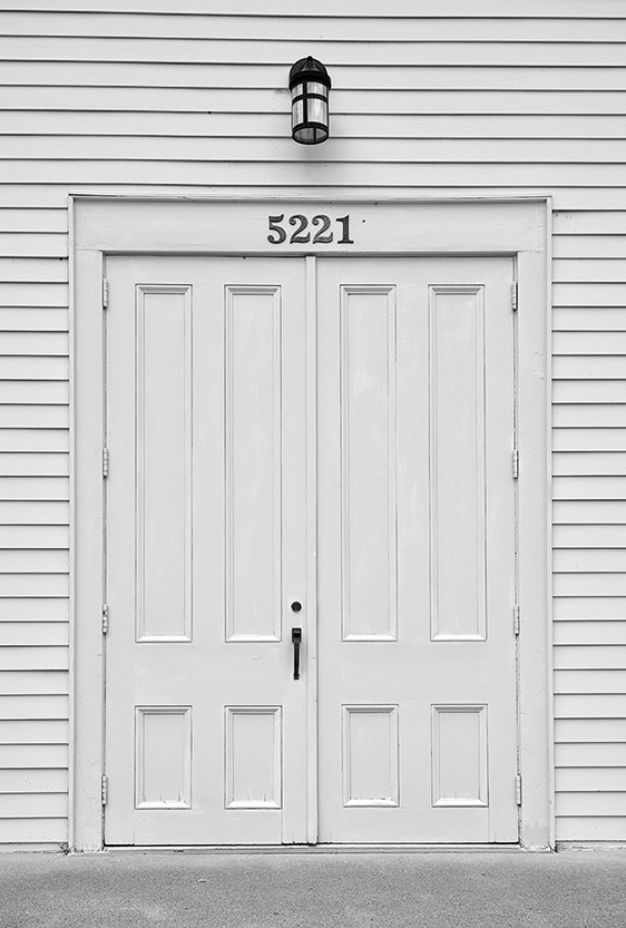 Two white doors from the outside of a building