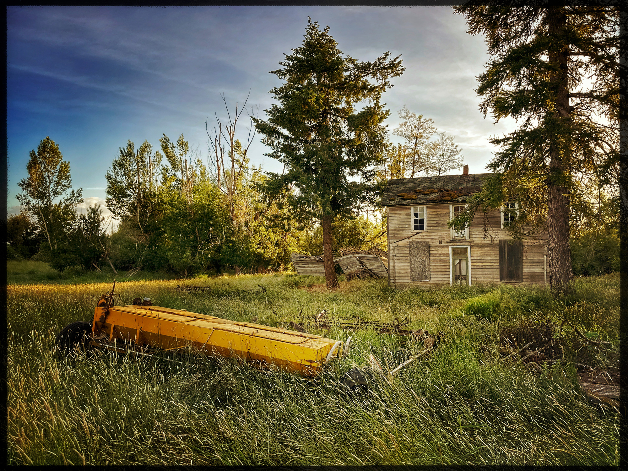 One day a family here closed the door for the last time and left. Truck, tractor, car and more is still where it was. The car showed a 1965 license plate,