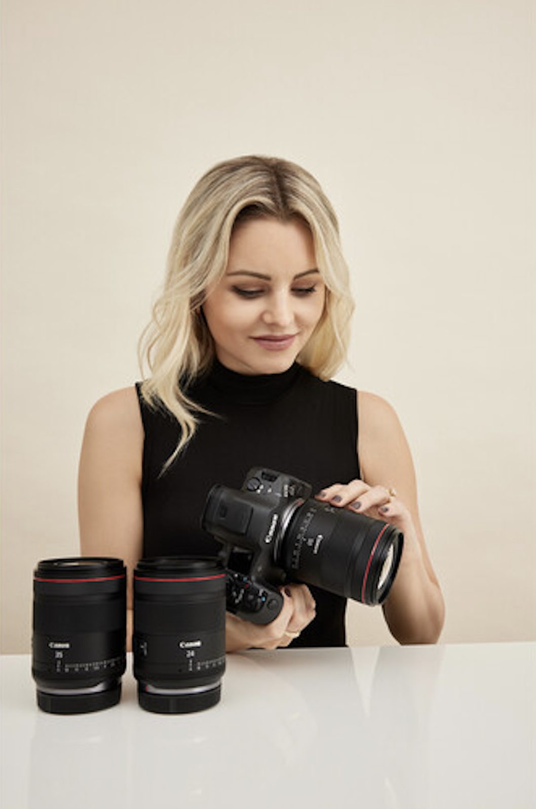 Woman holding a Canon VCM lens attached to a camera