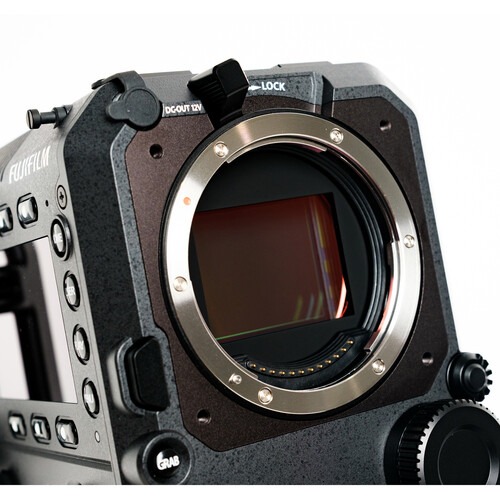An angled view of the Fujifilm GFX Eterna cinema camera body without a lens, showcasing its rugged black metallic chassis, the internal sensor, and the ergonomic "GRAB" and "REC" control buttons.