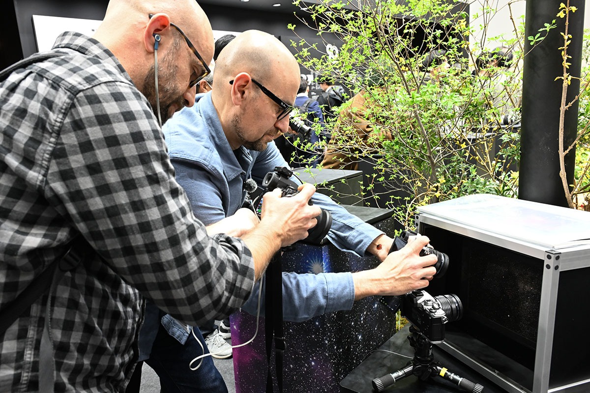 Two photographers testing cameras at a product demo booth