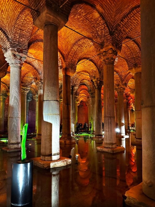 Basilica Cistern columns with green sculpture and warm reflections in Istanbul