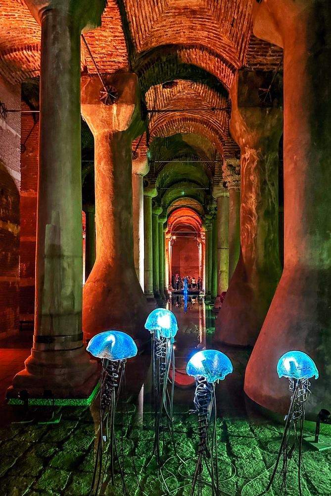 Blue jellyfish sculptures inside Basilica Cistern with columns and reflections