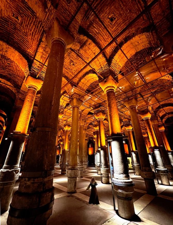 Binbirdirek Cistern columns with warm amber lighting and lone figure