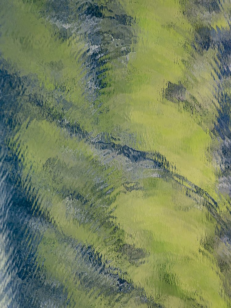 Rippling water in the Faroe Islands reflecting green and blue in layered wave patterns.