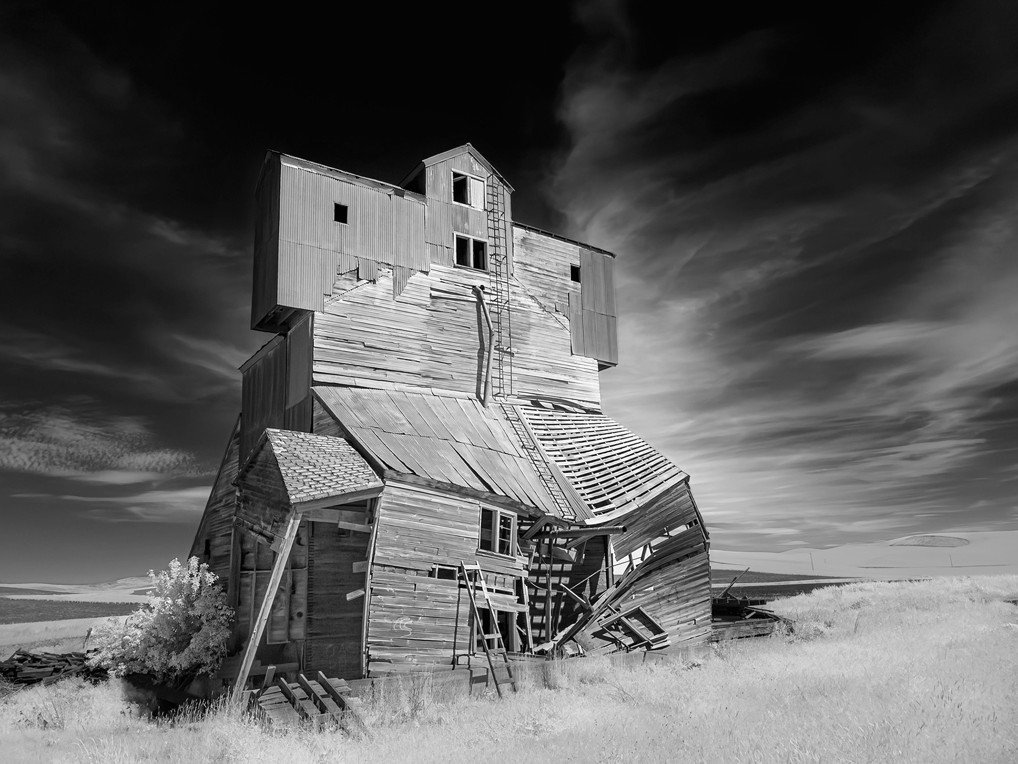 Infrared photo of an abandoned grain elevator under dramatic skies