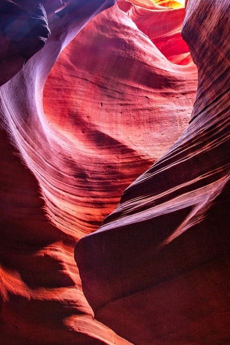 Curved red sandstone formations glowing with reflected canyon light