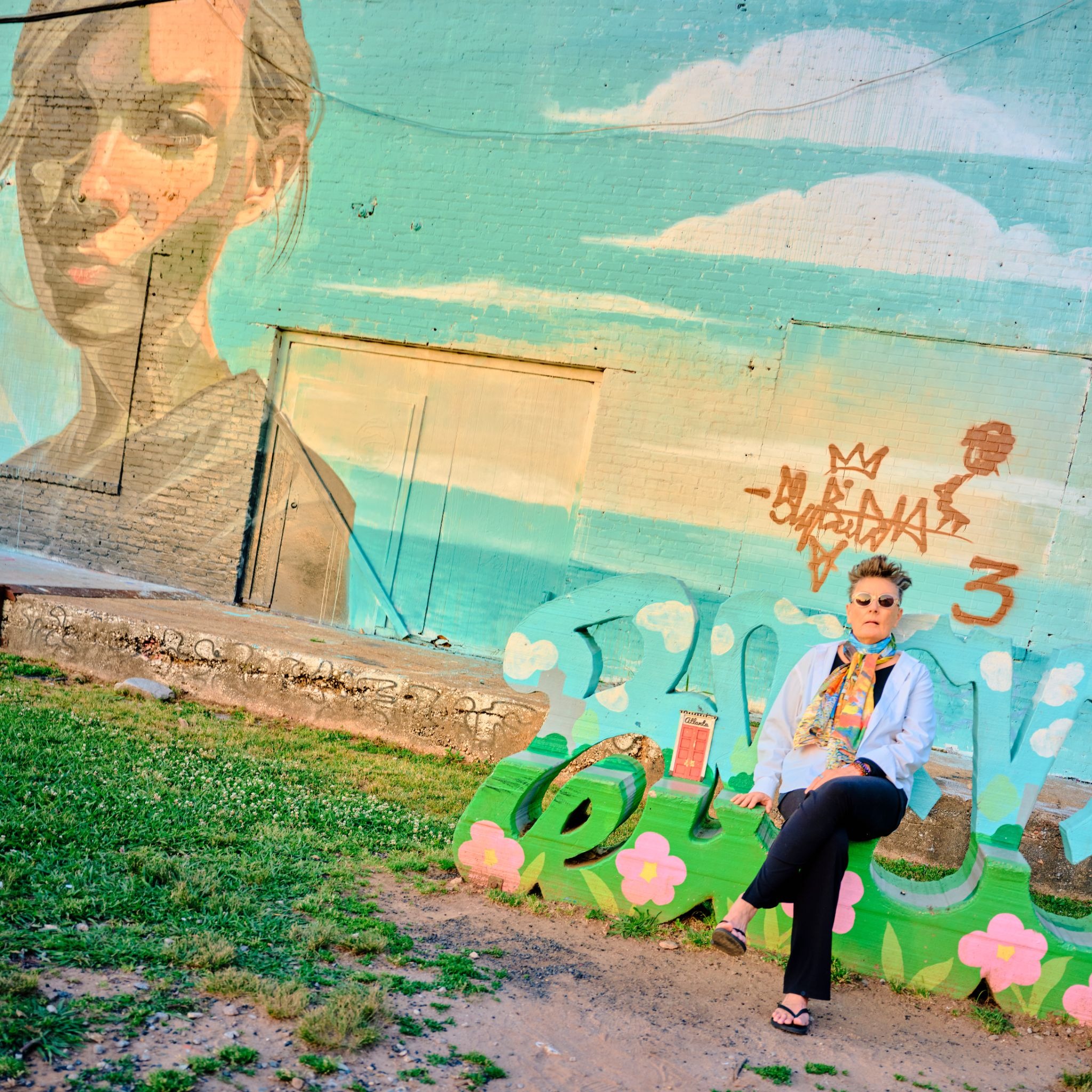 Person seated before a colorful mural, illustrating the GFX100RF's wide-angle perspective