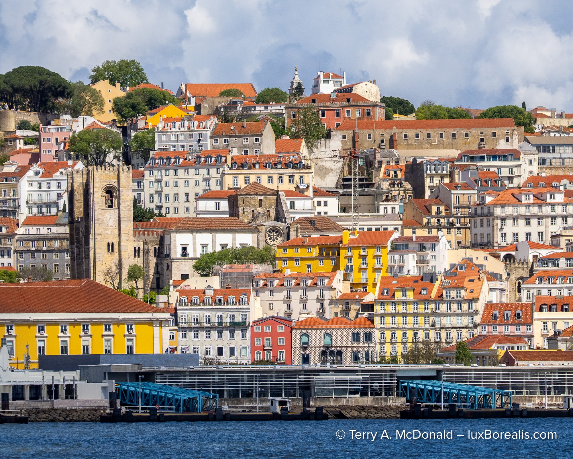 Colorful hillside buildings of Lisbon's Alfama district viewed from the waterfront