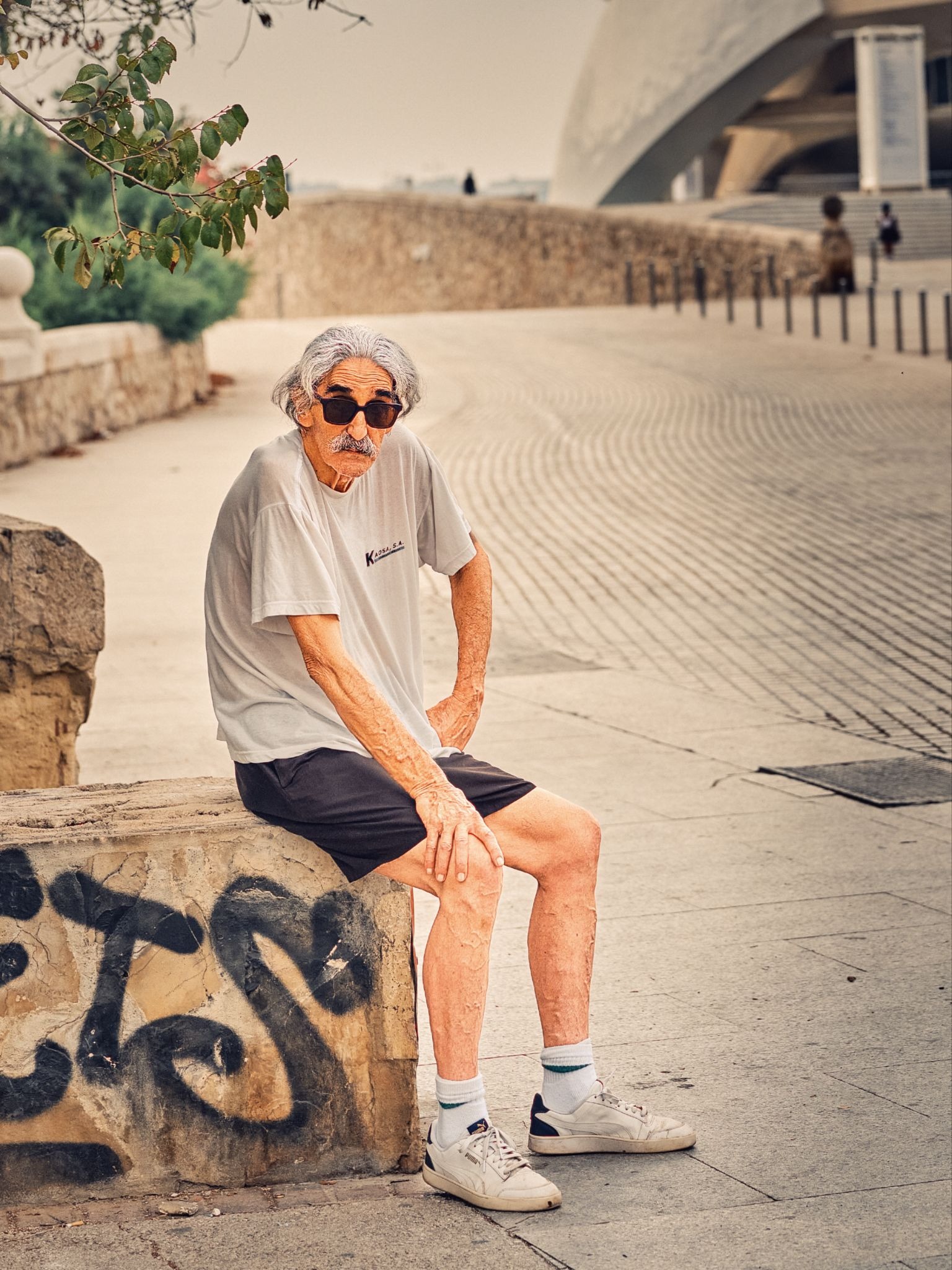 Cropped Portrait of an older man seated near Valencia's modern architecture.