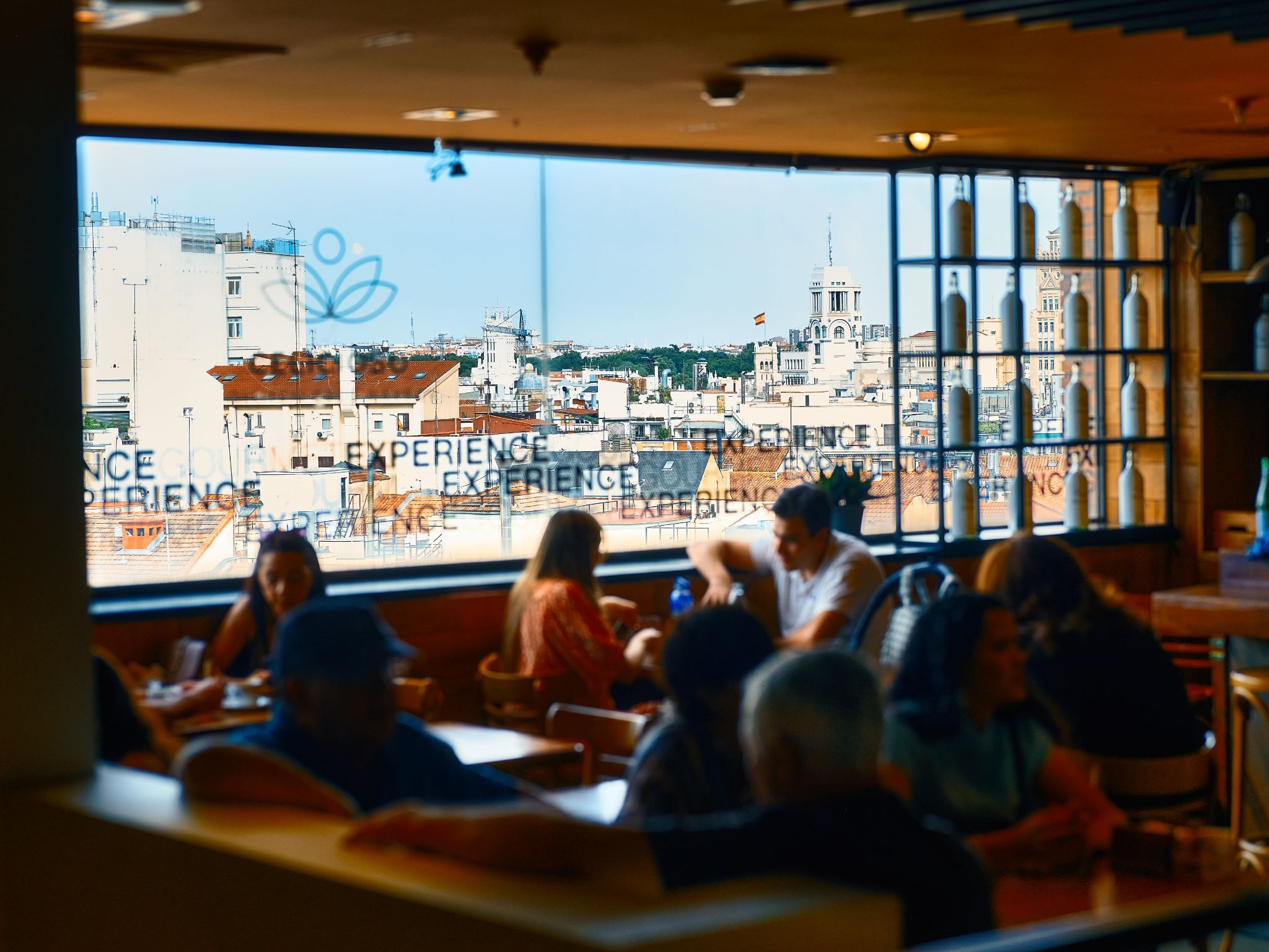 People dining inside a café overlooking the Madrid skyline.