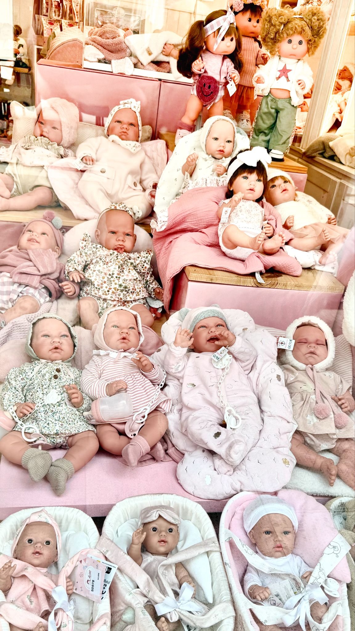 Display of lifelike baby dolls in a shop window.