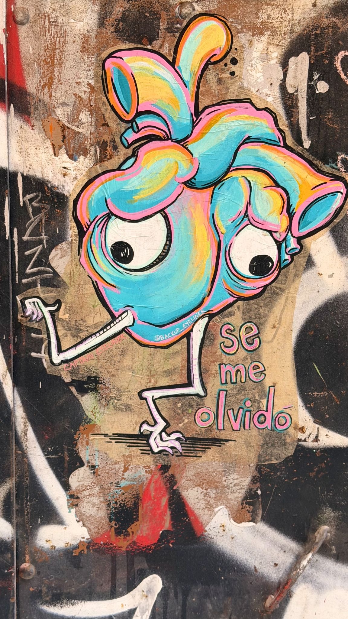 Colorful graffiti of a cartoon heart with Spanish text.