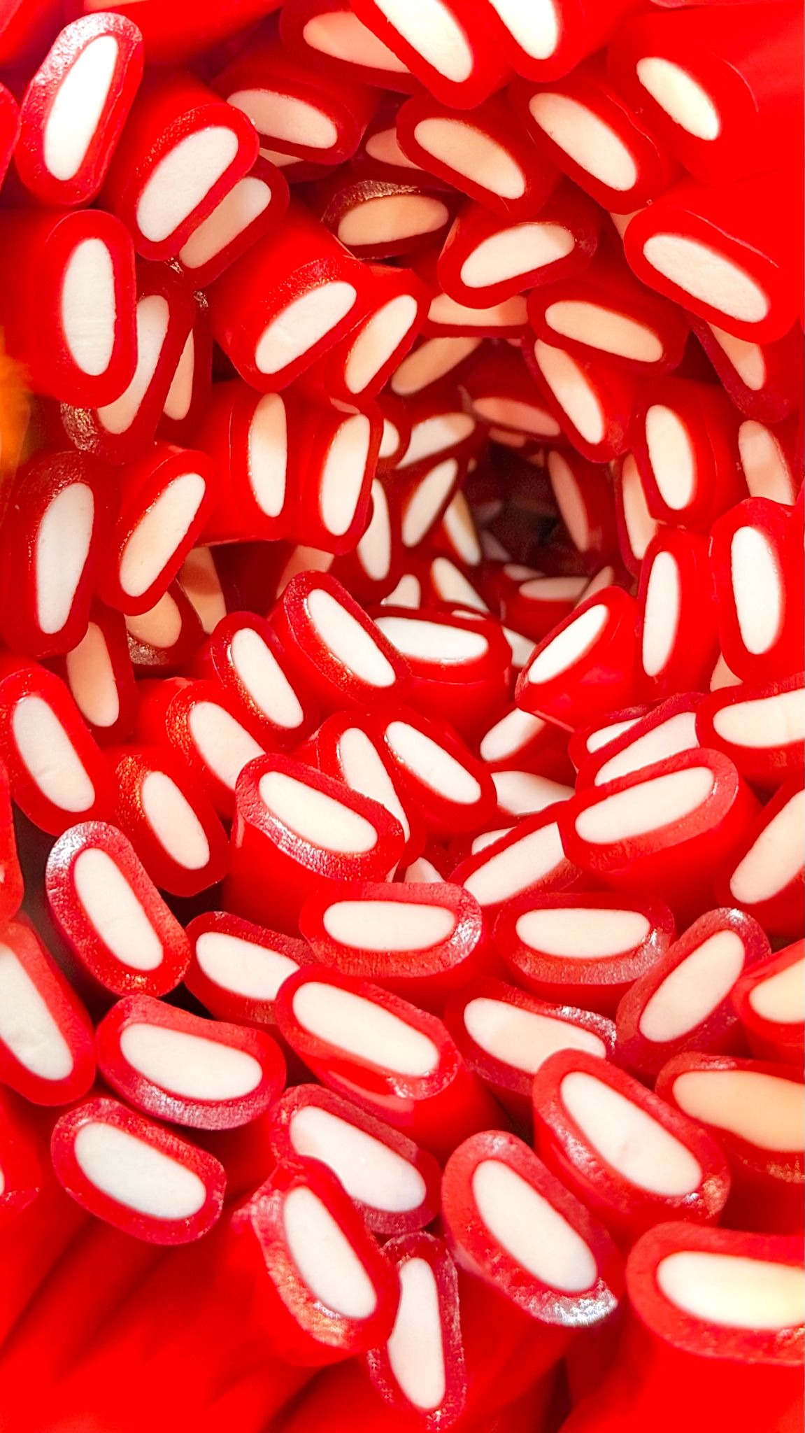 Close-up of red and white gummy candies in a display.