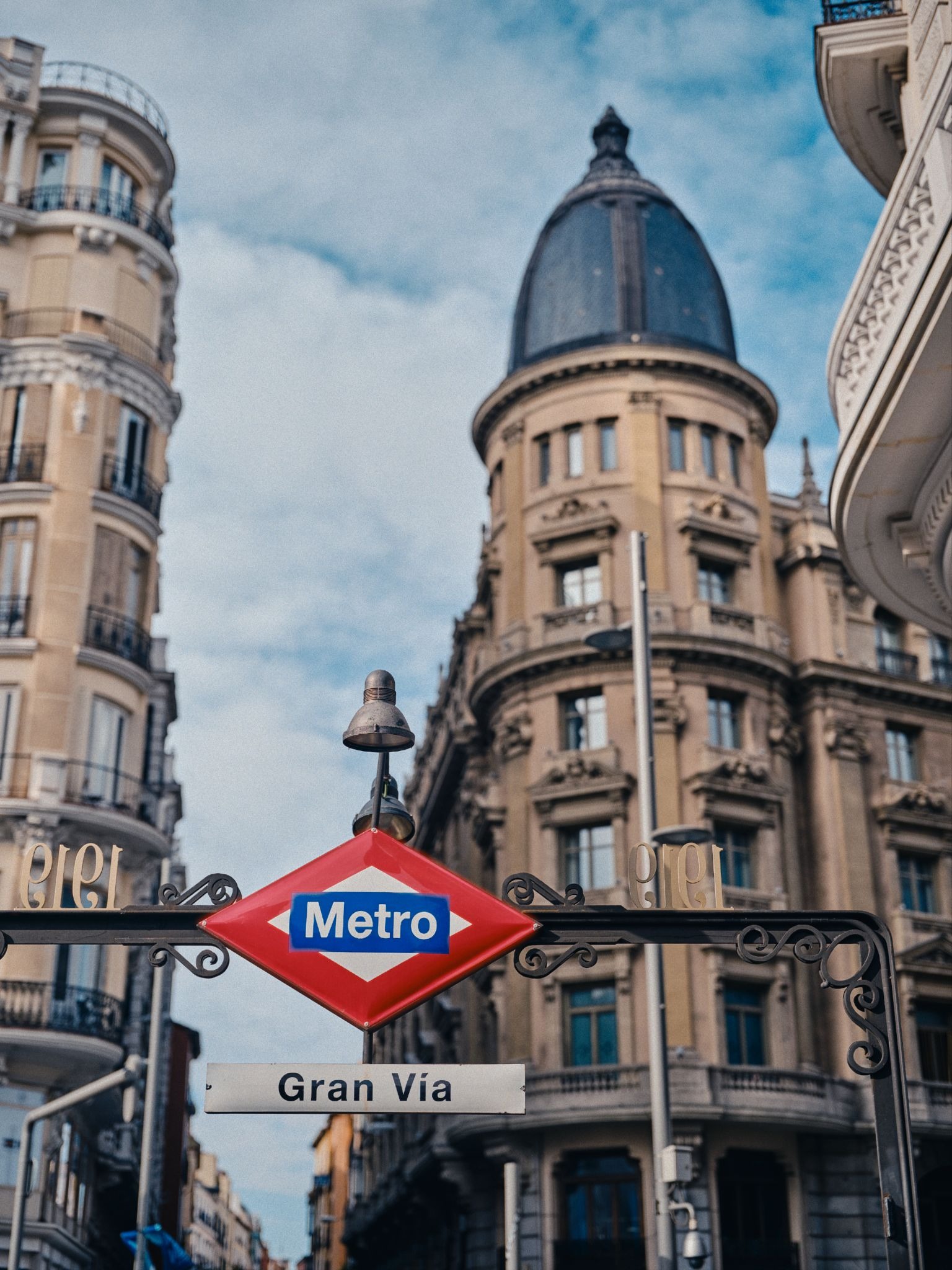 Gran Vía Metro entrance with historic buildings in Madrid.