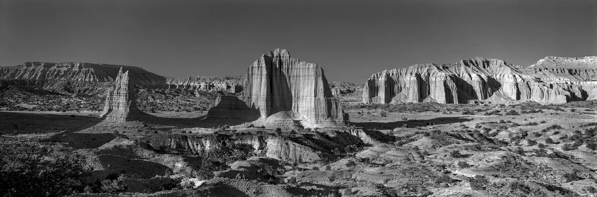Panoramic view of towering desert cliffs and rock formations in black and white
