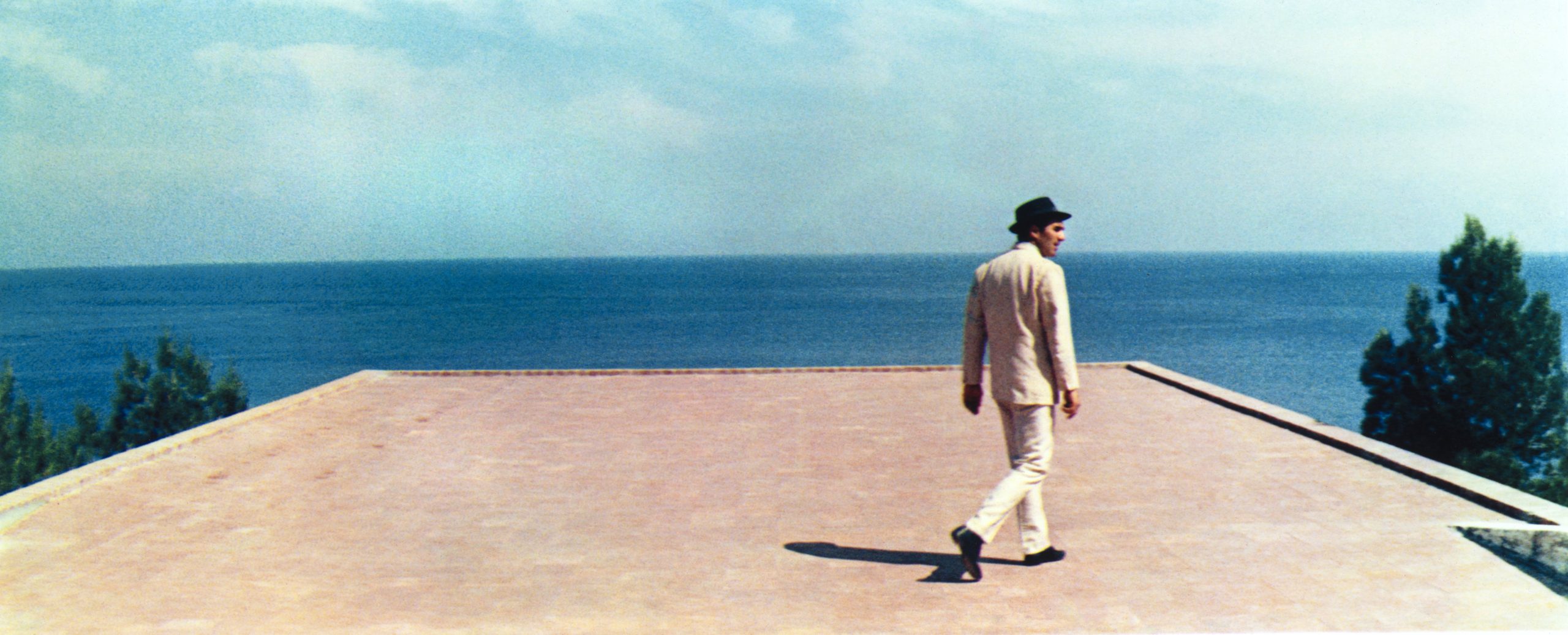 Jean Curran Godard Bardot print showing a man walking beside the sea