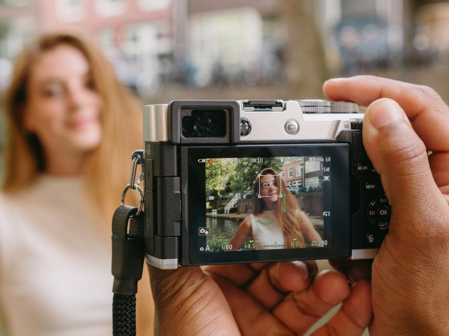 Photographer using the OM SYSTEM PEN to capture a portrait -Ai Subject Detection AF
