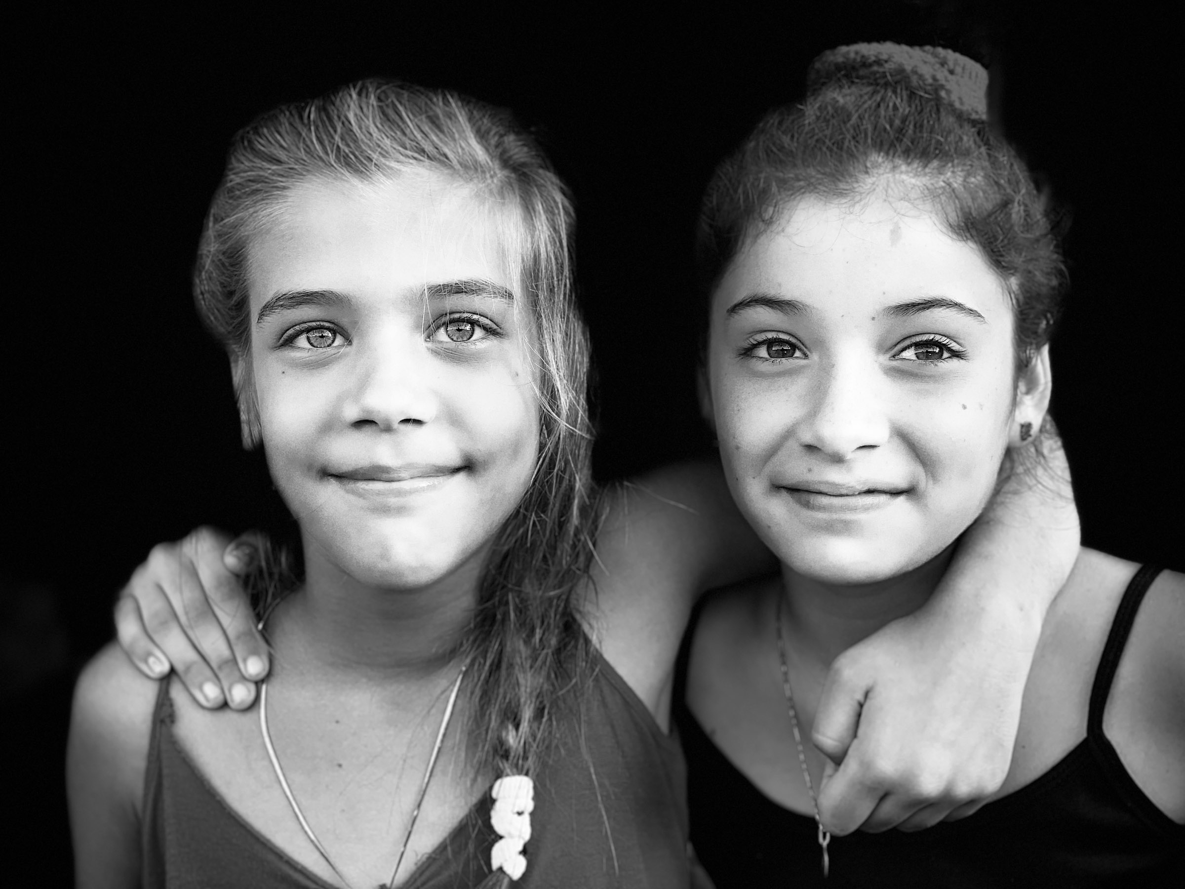 Two young female friends posing together in a black-and-white portrait in Viñales, Cuba.