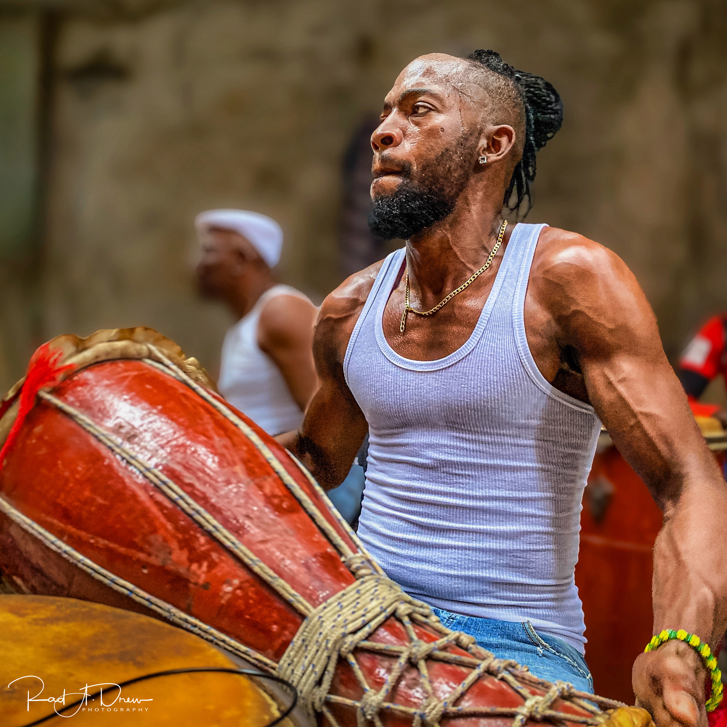 Afro-Cuban drummer playing a traditional drum during a performance.