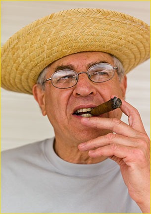 Jay Maisel wearing a straw hat and holding a cigar
