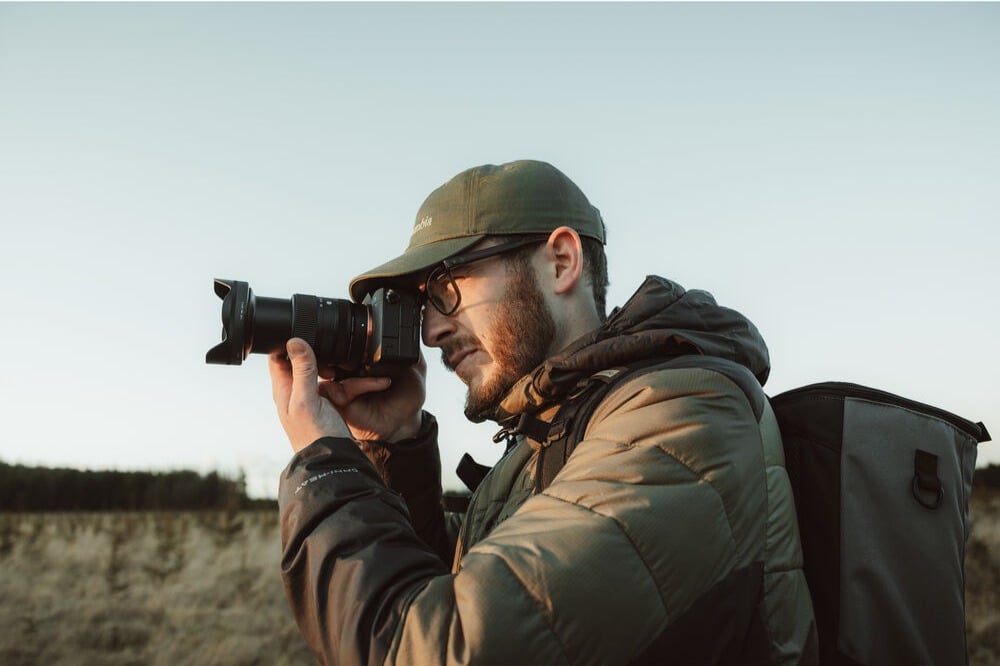 Photographer using the Sigma 20-60mm F2.8-4 DG Contemporary lens outdoors