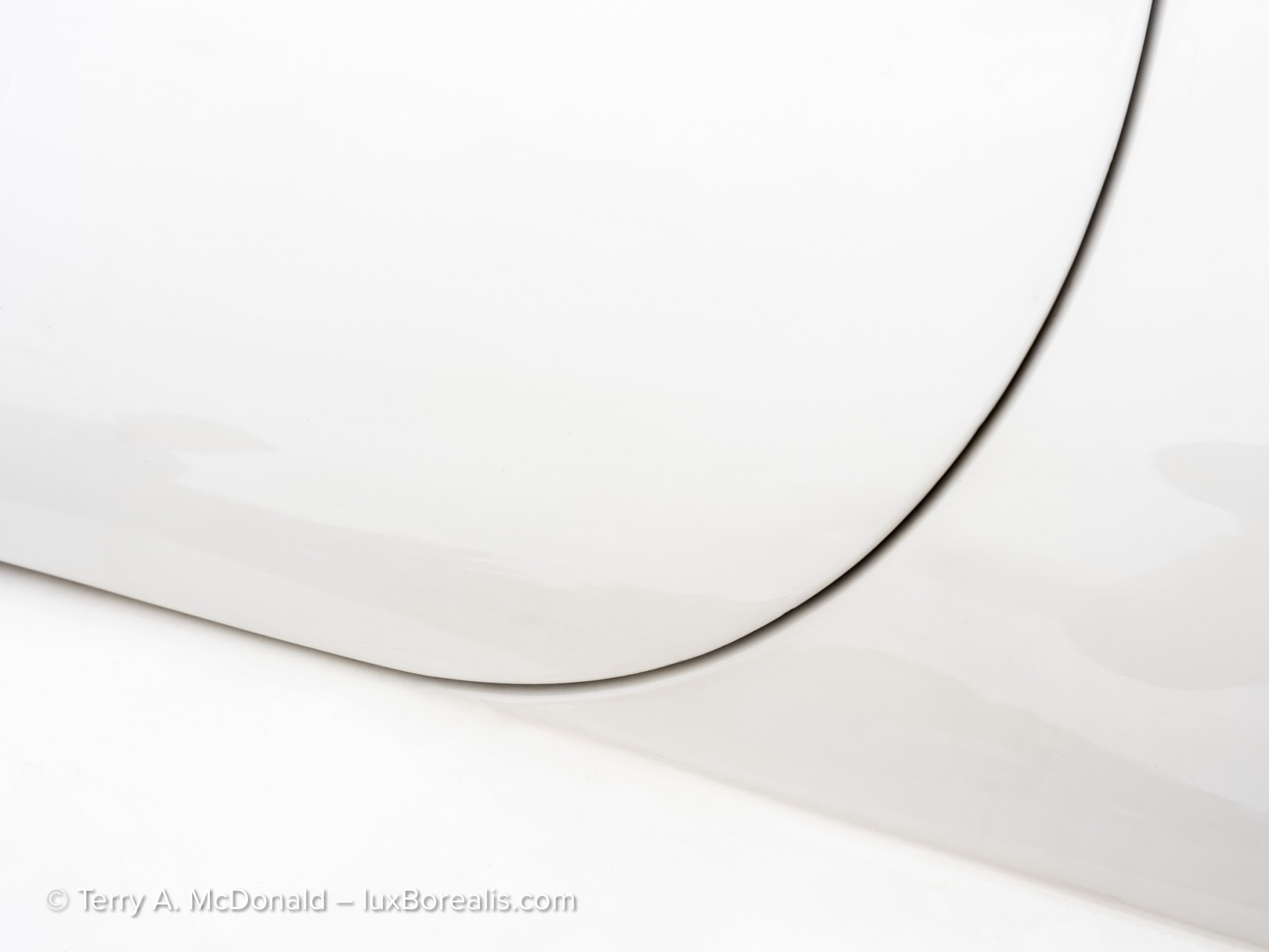 Close-up photograph of the precision lines and cream-colored finish of a 1959 Jaguar XK 150.