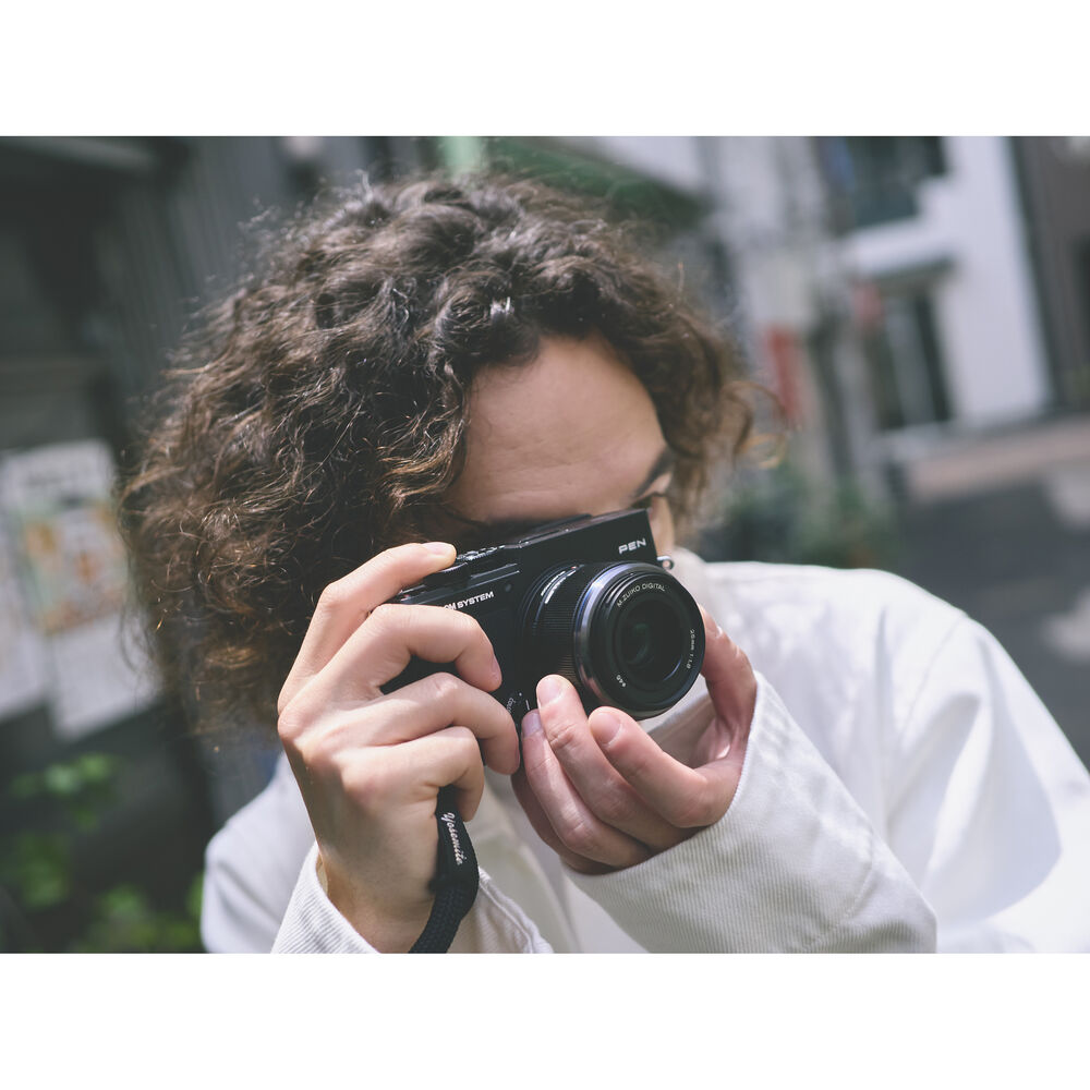Photographer using the OM SYSTEM PEN for street photography