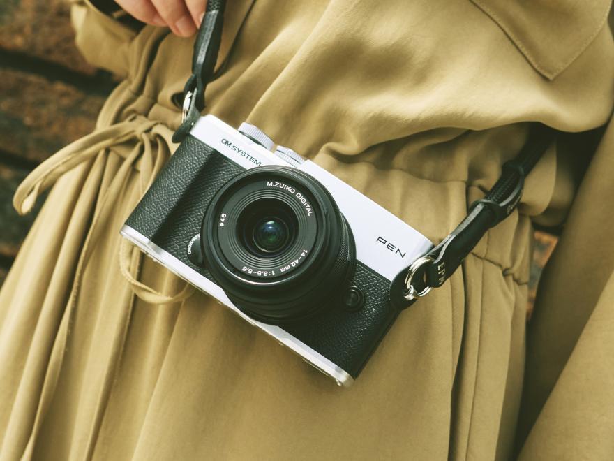 Silver OM SYSTEM PEN with 14-42mm lens worn as an everyday camera