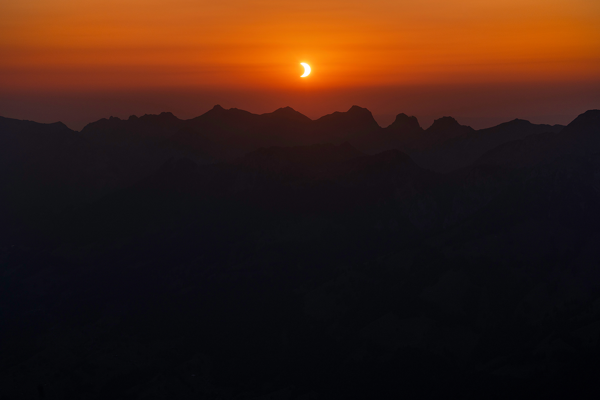 Solar eclipse over Mount Niesen at sunset