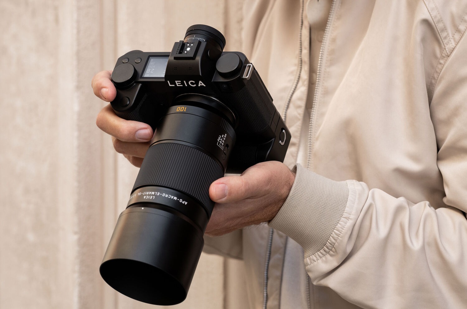 Photographer holding a Leica camera with the APO-Macro-Elmarit-SL 100 f/2.8 lens