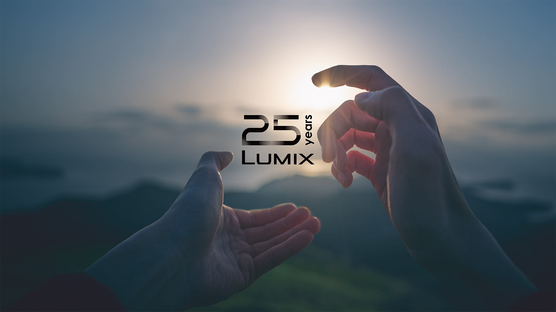 Hands framing the sun with the Lumix 25th anniversary logo