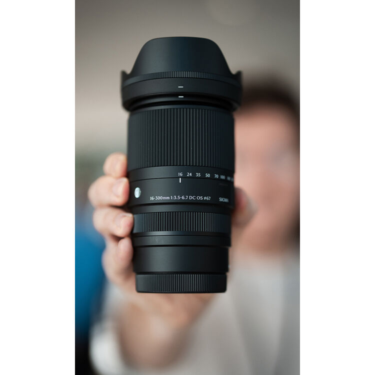 Photographer holding the Sigma 16-300mm F3.5-6.7 travel zoom lens